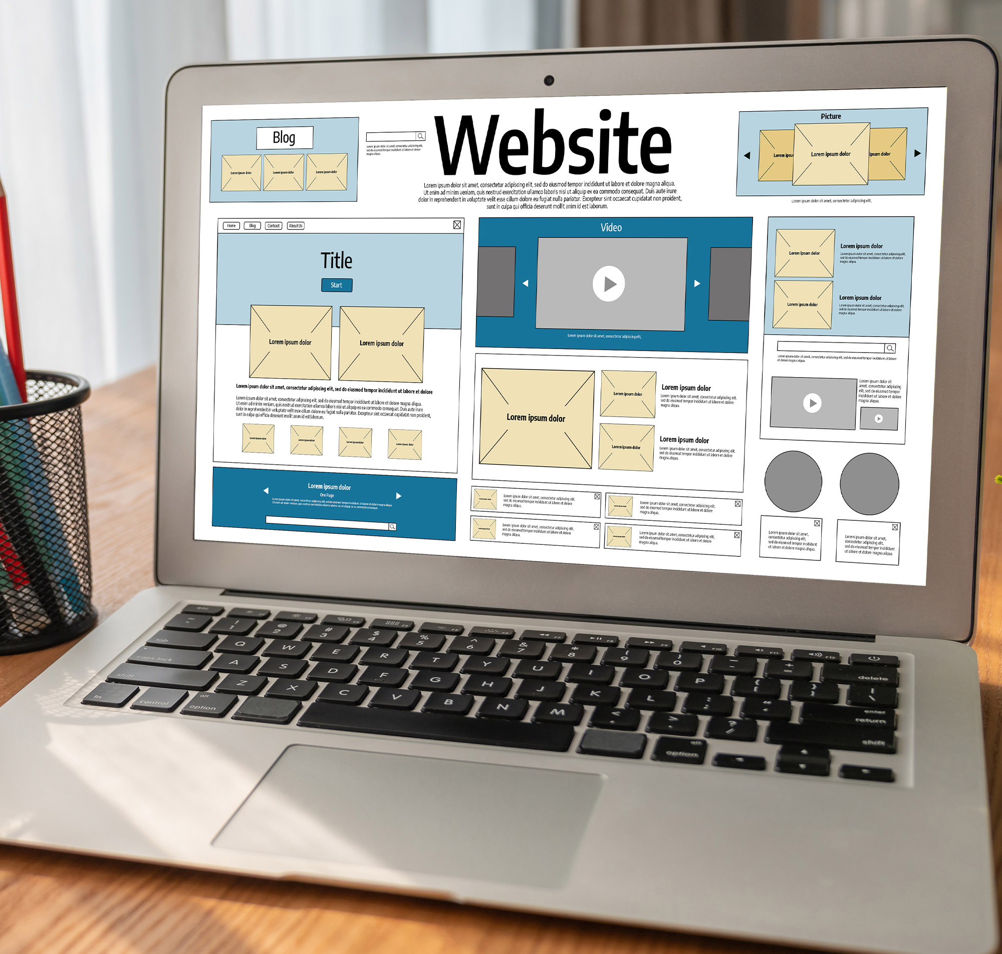 Ein Laptop zeigt ein Website-Layout mit verschiedenen Elementen wie Blog, Video und Bildern zur Gestaltung.