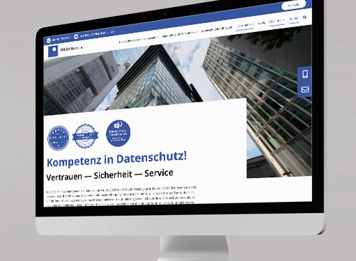 Ein Computerbildschirm zeigt eine Webseite über Datenschutzkompetenz mit Vertrauenssymbolen und Dienstleistungen.