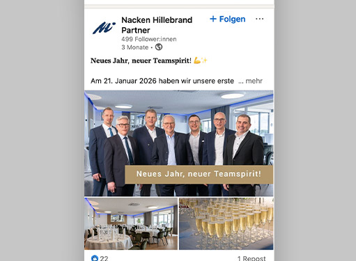 Gruppenfoto von sechs Männern in Anzügen, die in einem modernen Büro lächeln, mit Sektgläsern im Hintergrund.