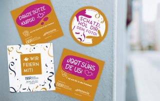 Bunte Werbematerialien für eine Fotobox-Aktion mit einladenden Slogans und fröhlichem Design.
