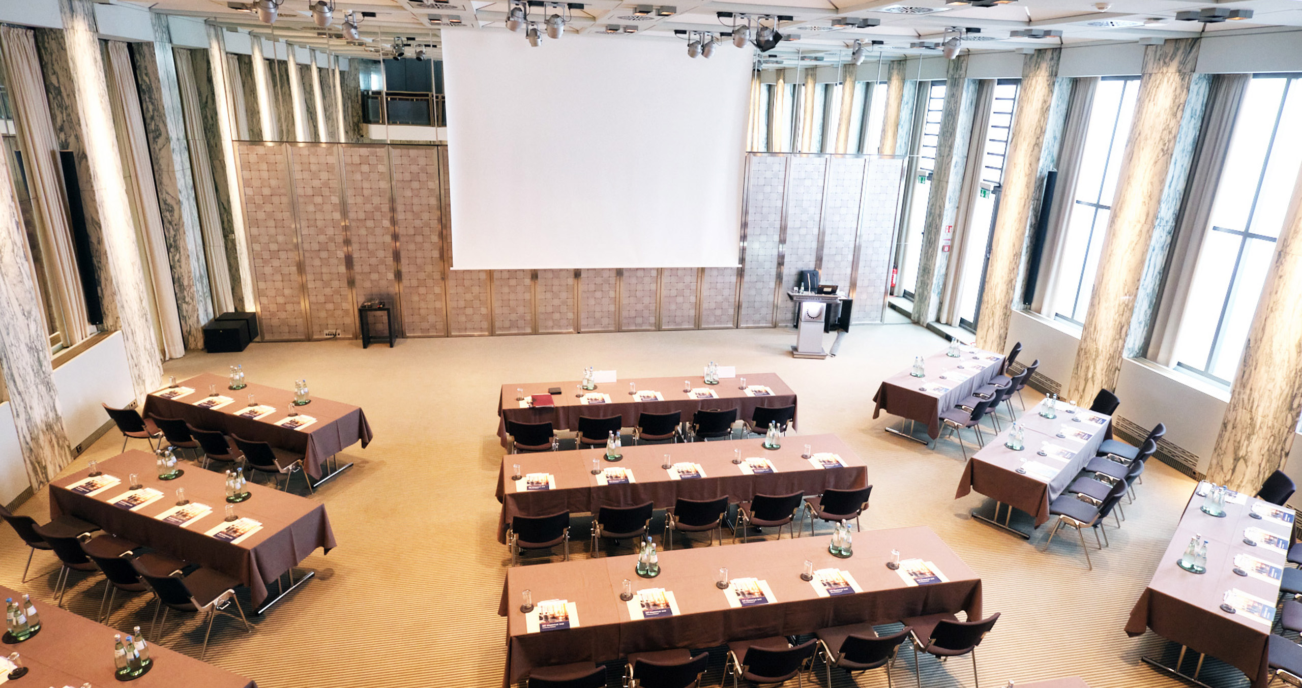 Moderne Konferenzräume mit Tischen und Stühlen, ideal für Meetings und Veranstaltungen in einem eleganten Ambiente.