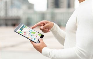 Eine Person, die auf einem Tablet mit einer Kartenanwendung navigiert, um den besten Weg zu finden.