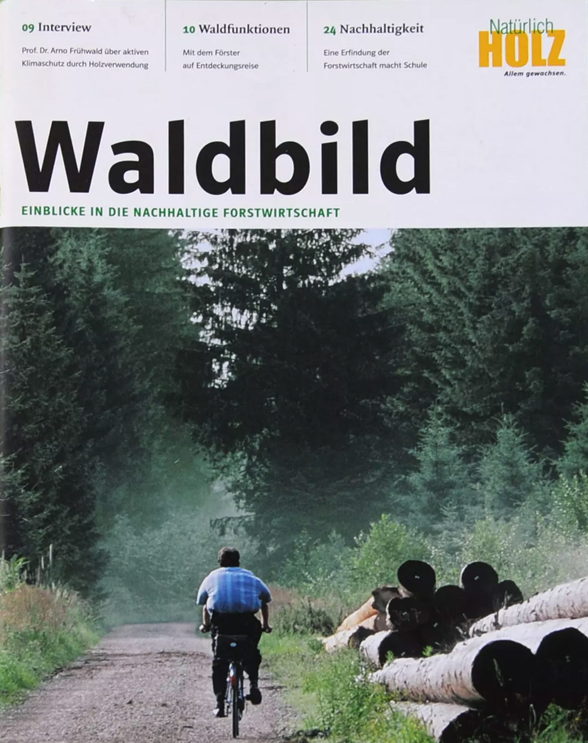 Titelblatt der Zeitschrift Waldbild mit einem Radfahrer auf einem Waldweg und gestapelten Baumstämmen am Rand, umgeben von dichten Nadelbäumen.